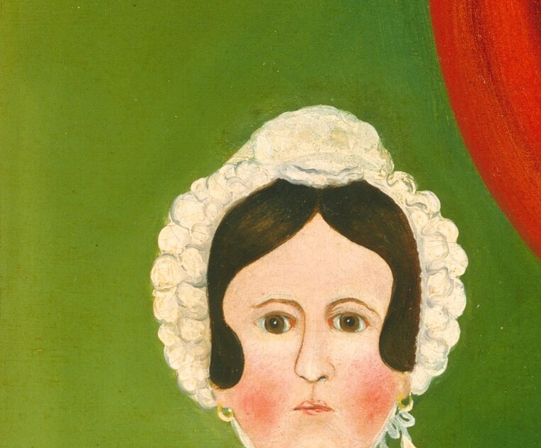 Her direct gaze and rosy cheeks suggest a calm, perhaps slightly melancholic, presence.