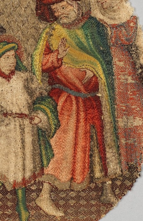 His father, in red, reacts with an outstretched hand, a gesture of surprise.