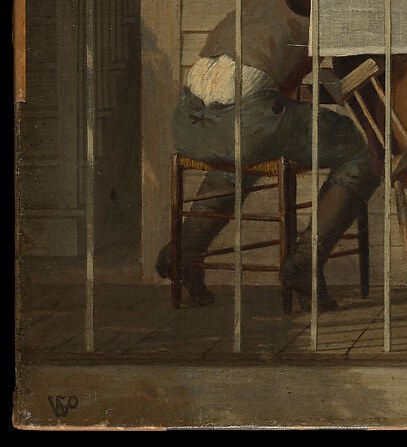 He sits in a plain kitchen chair, not a throne.