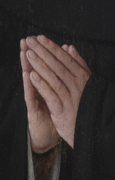 His hands are clasped in prayer.