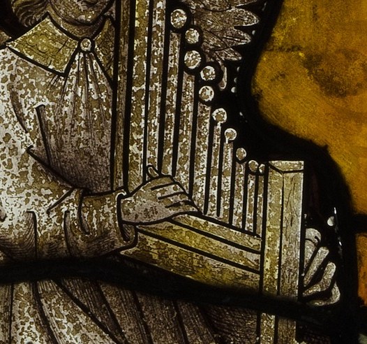 This instrument, likely a portative organ, signifies celestial music and divine harmony.