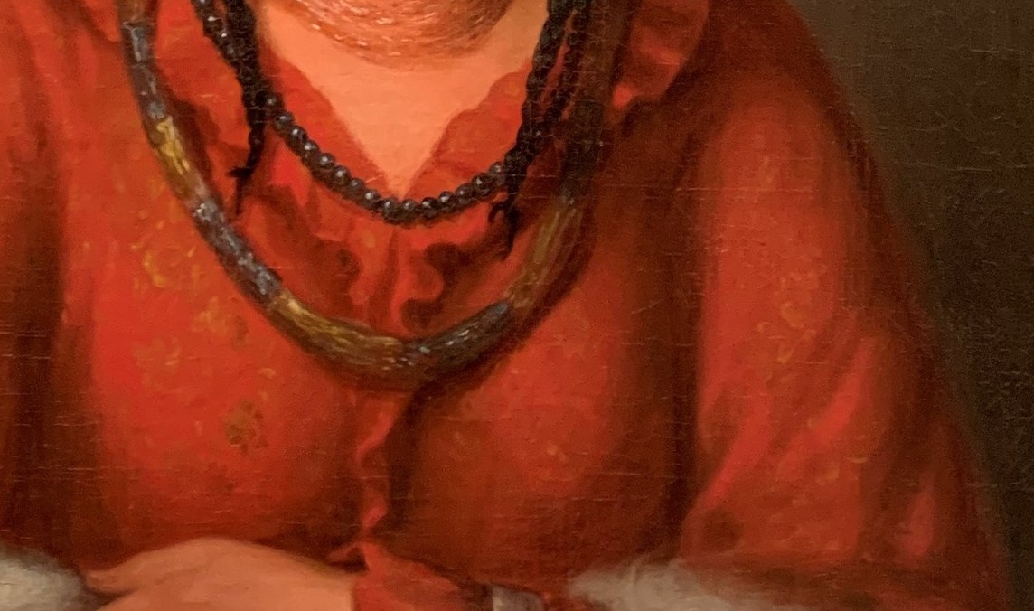 Look at the rich texture of her red dress and white shawl.
