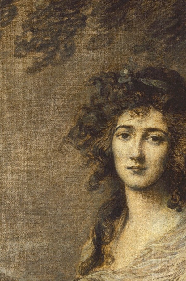 The voluminous, tousled curls add a touch of romanticism and softness to her appearance.