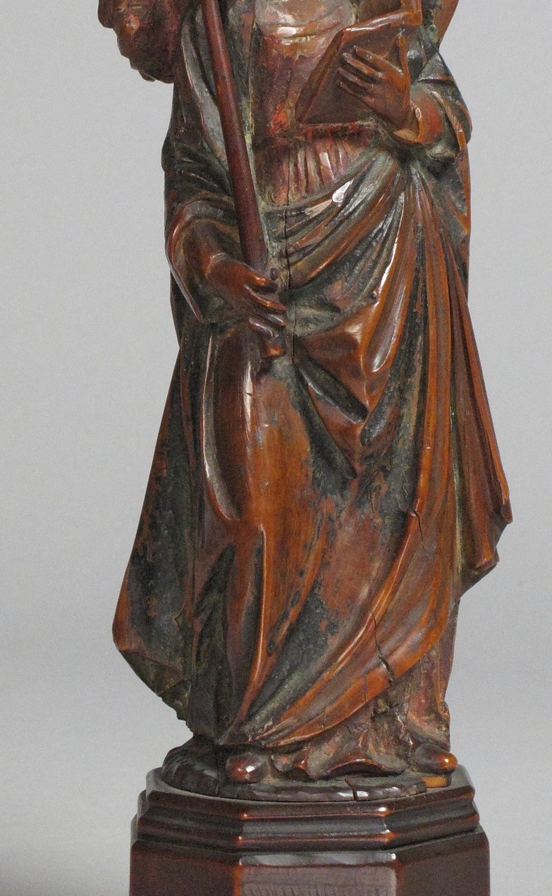 The red drapery is the carver's showpiece , deep-undercut folds in solid wood simulate liquid fabric; the surviving paint makes this a rare document of 15th-century church color