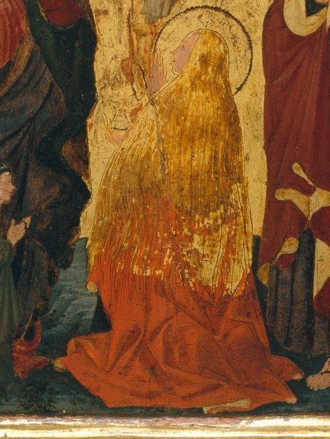 This woman, cloaked in orange, prostrates herself in despair.