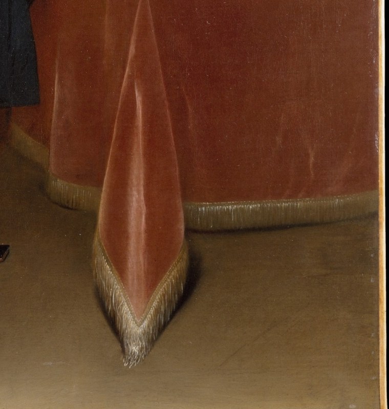 The rich red tablecloth also underscores his affluent position.