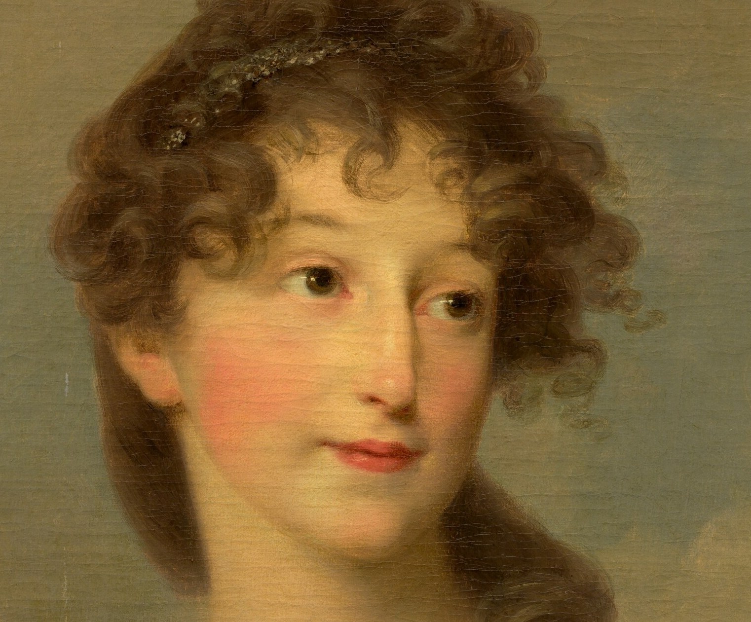 The loose curls and tendrils frame her face, adding to the romantic and slightly disheveled aesthetic.