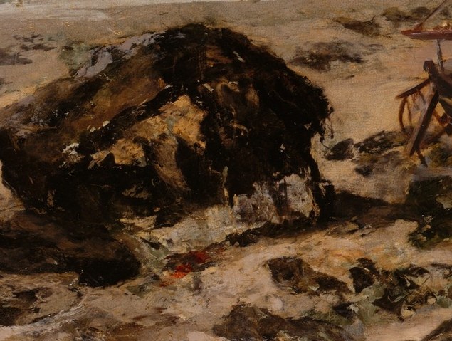 Its dark, imposing form contrasts with the lighter sand and sea, adding visual weight to the foreground.