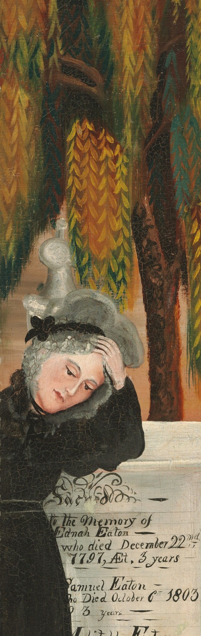 A woman in mourning leans over the monument.