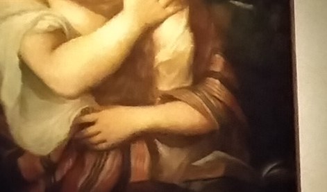 Her hands, clasped in repentance, catch the light.