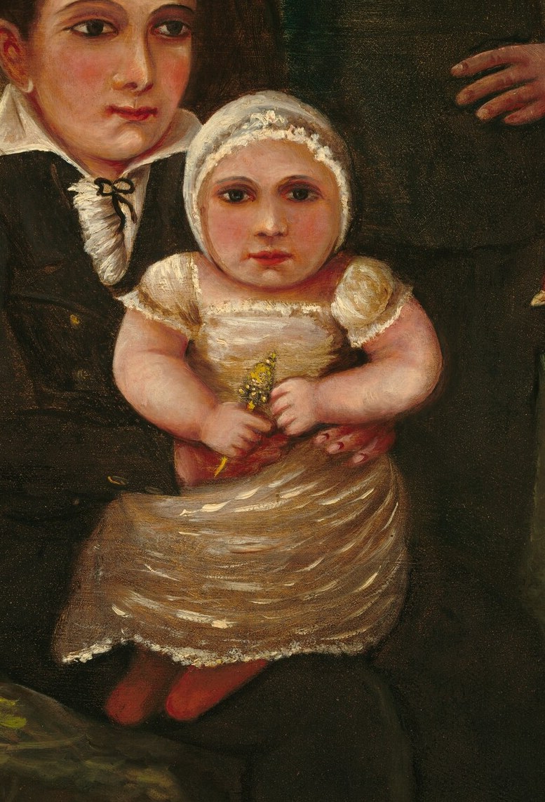 His wife gently holds their youngest child, clutching flowers.
