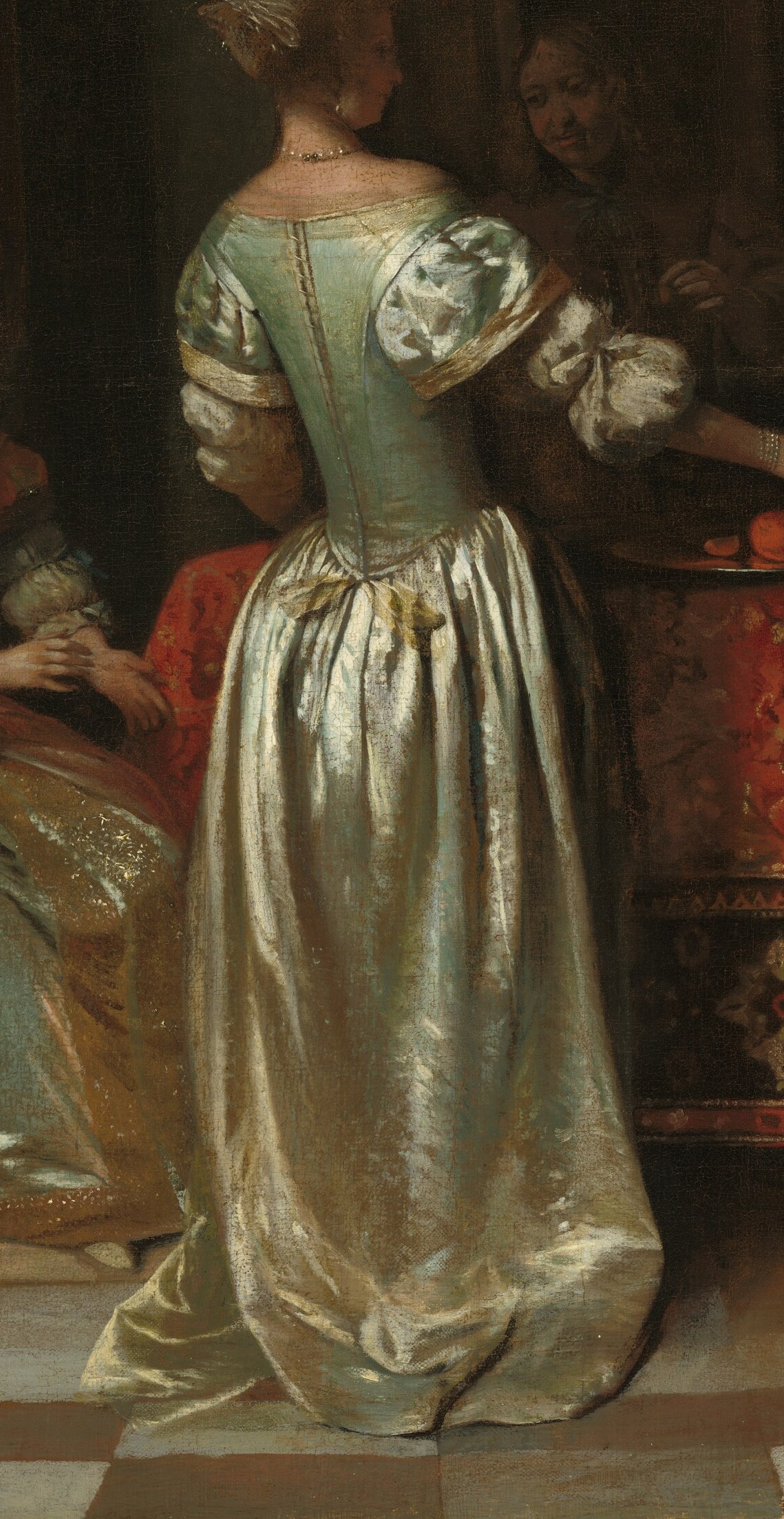The woman in the shimmering silver dress is being greeted.