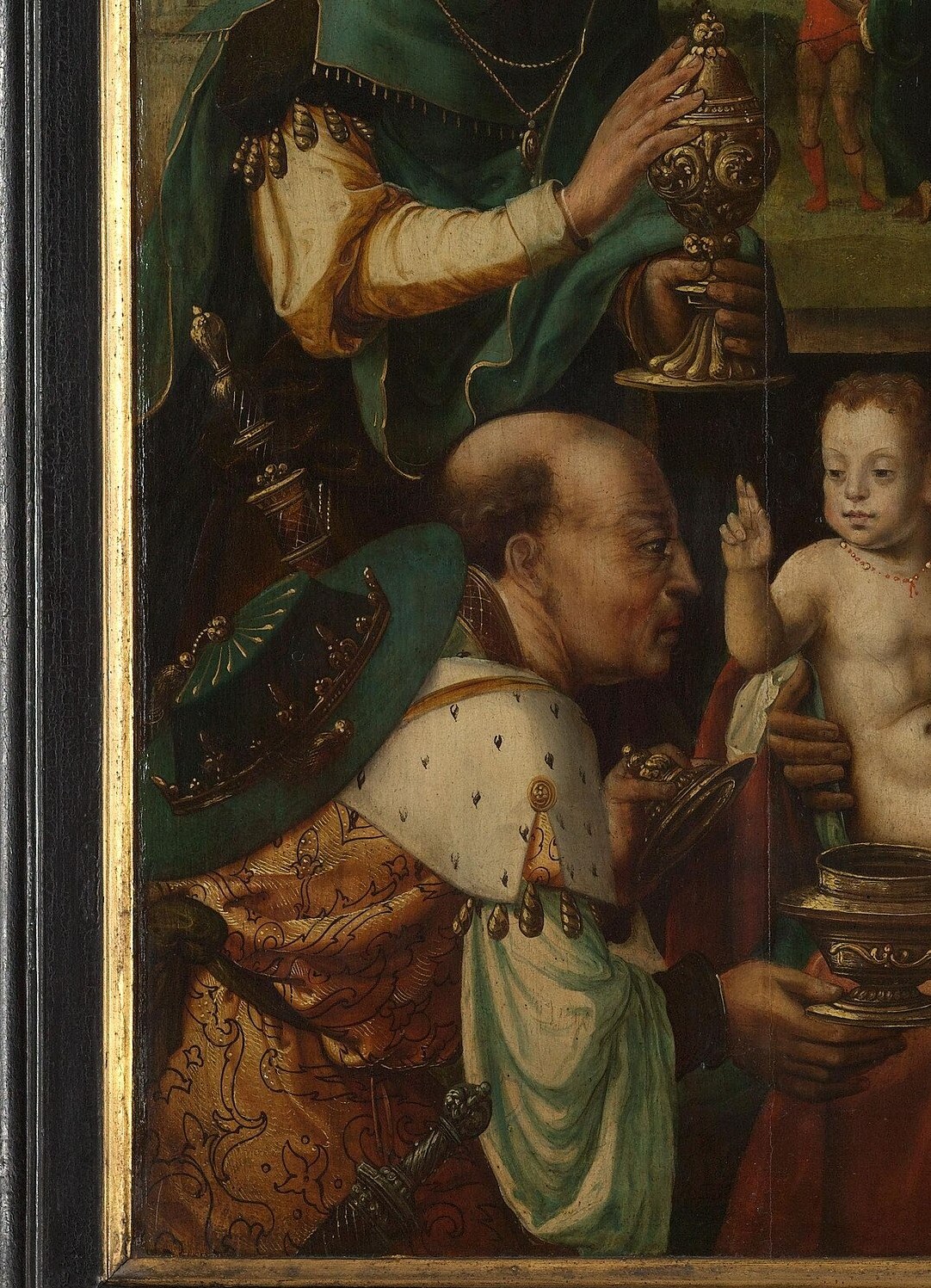 The kneeling king offers an ornate golden vessel.