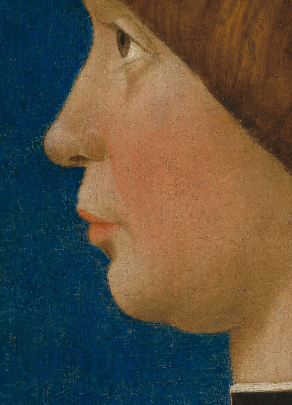 His profile captures a quiet dignity, typical of early Renaissance portraits.