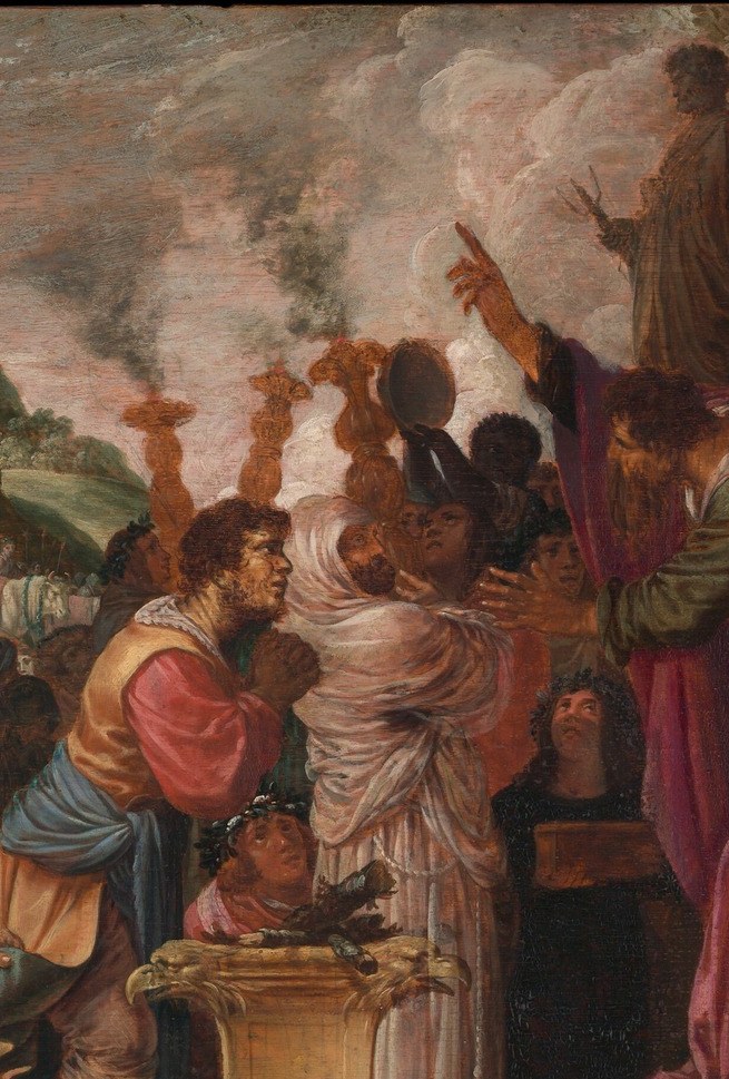 A man in the crowd raises both arms high, invoking the ritual.