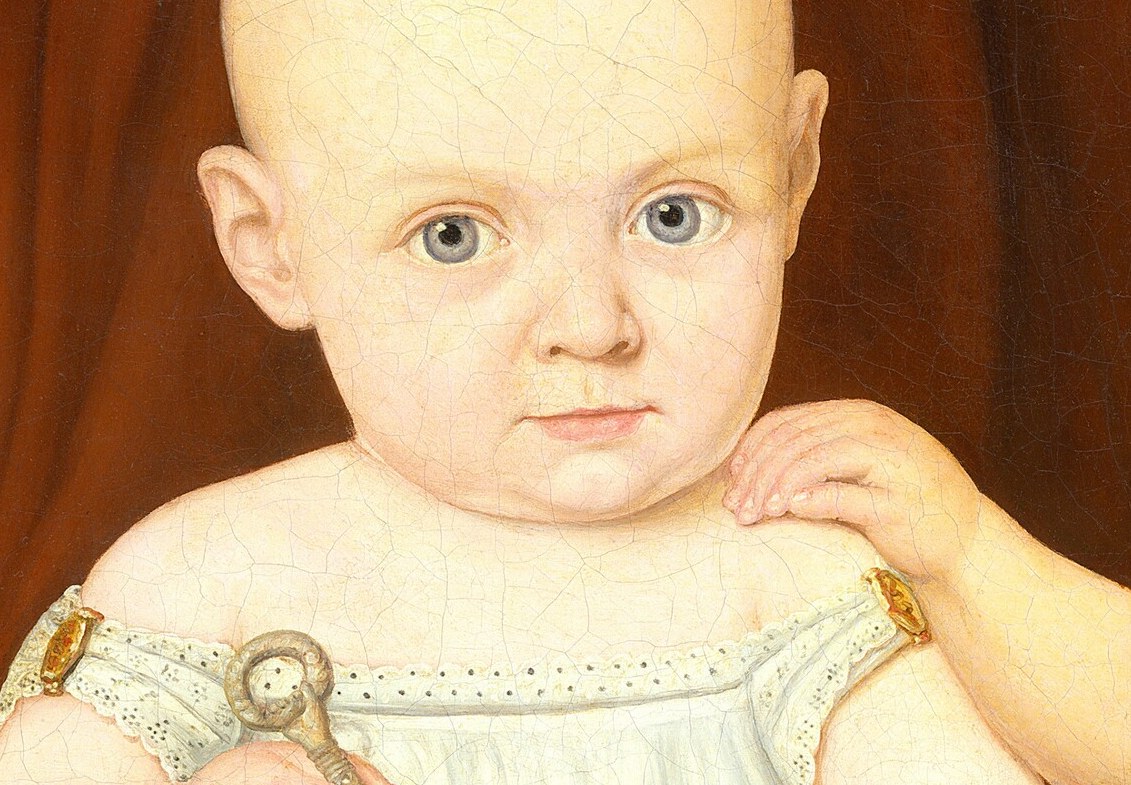 The baby's wide, innocent eyes and smooth skin convey a sense of vulnerability and pure childhood.