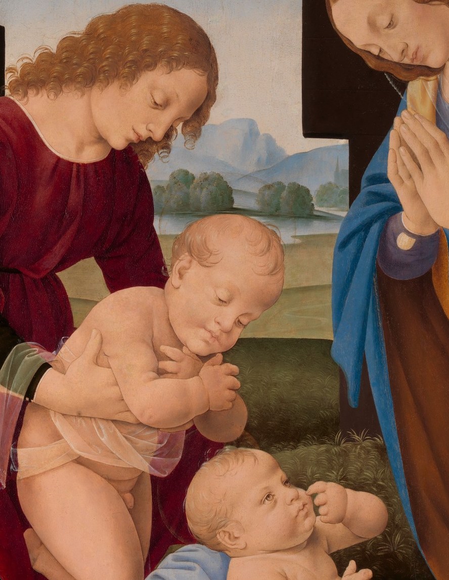 The baby in red reaches forward urgently.