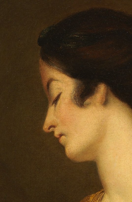 Her downcast gaze and gentle profile suggest introspection or quiet contemplation.