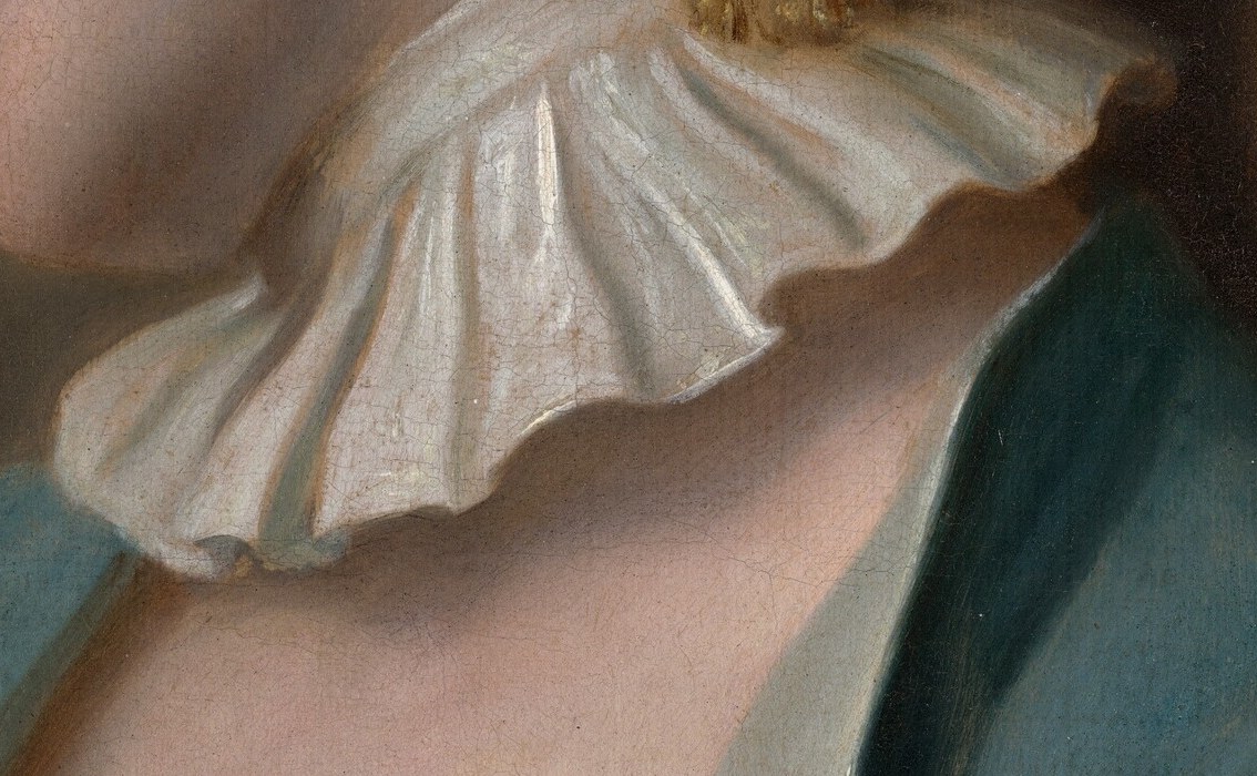 The delicate, layered fabric of the collar contrasts with the smoothness of her skin and the richness of her attire.
