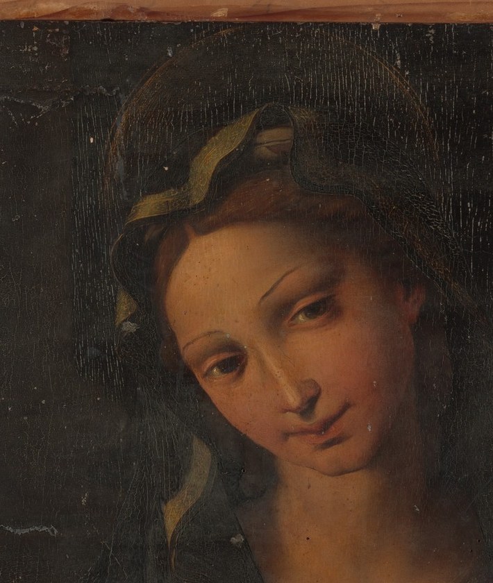 Unbound hair signals virginal purity in Renaissance Marian iconography; the warm auburn tones warm the otherwise cool upper composition and echo the red dress below