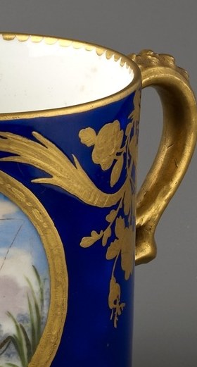 The elaborate, curved handle is a key feature of the cup's design and ergonomics.