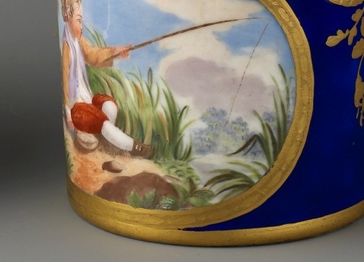 On the cup, a boy fishes by a stream.