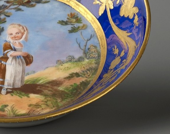 The saucer shows a girl in a quiet landscape.
