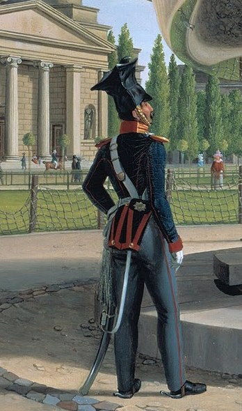 A soldier stands rigid, formal, by the fountain.