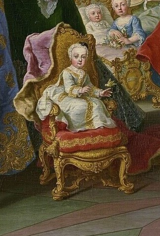 The tiniest future monarch sits in her own small gilded chair.