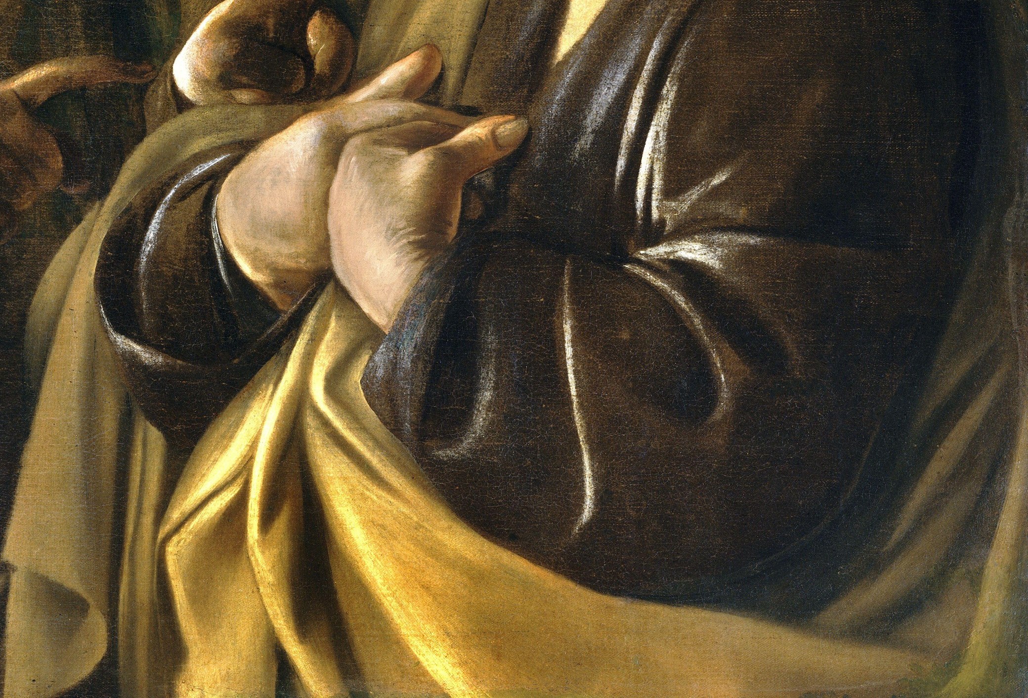 Caravaggio's virtuoso fabric painting; the warm gold blazes against surrounding darkness , a cruel irony of warmth for the coldest act in an Apostle's life.