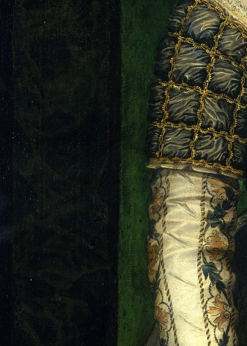 The slashed sleeve deliberately exposes expensive white silk beneath. A fashion of the elite.