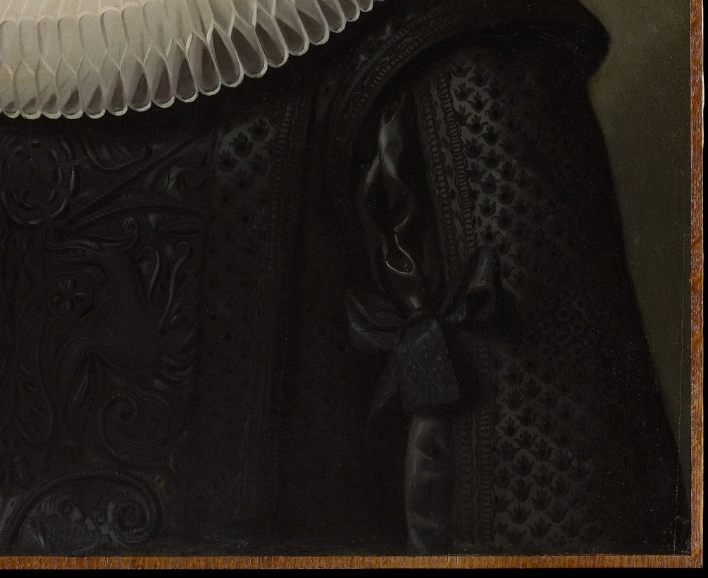 Look closely at her dark, patterned dress.