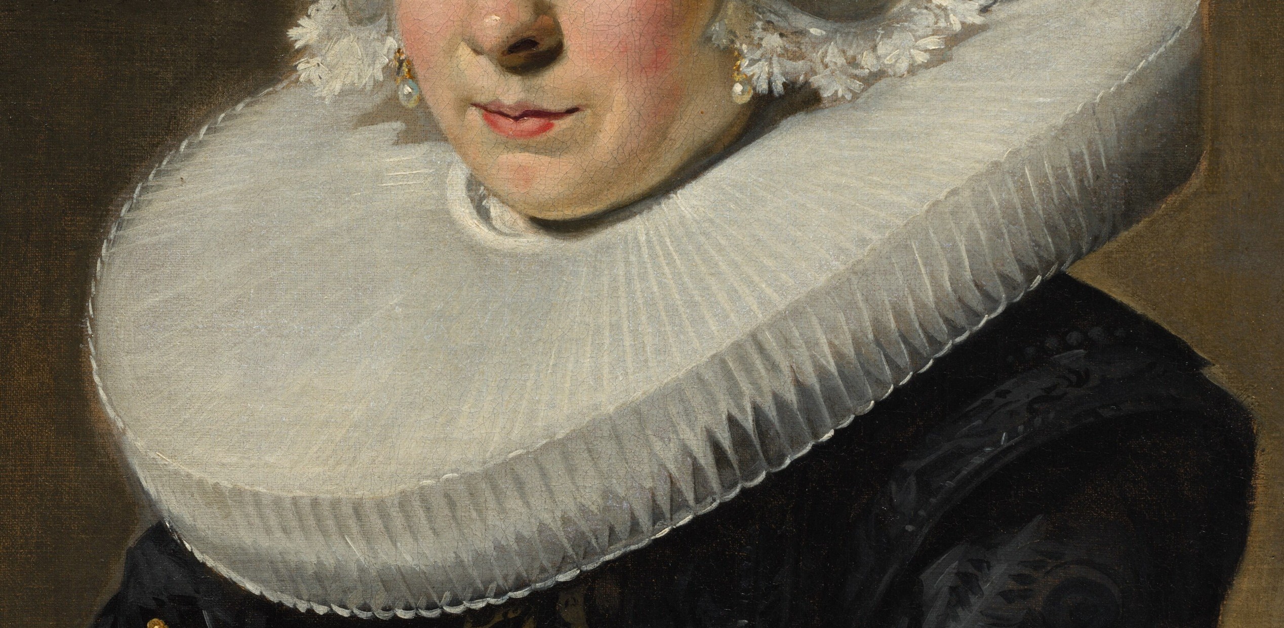 Look closely at her elaborate lace ruff and cuffs.