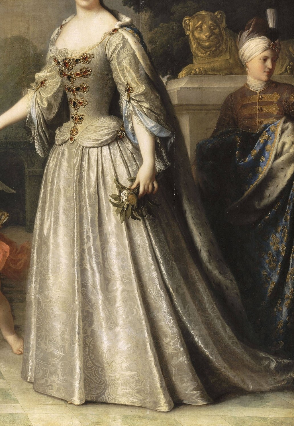 Her opulent silver gown shows her immense wealth and status.