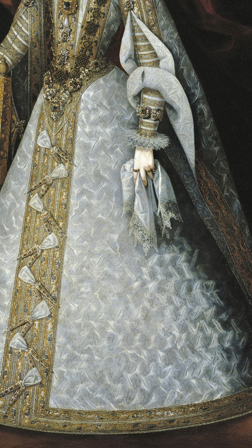 She wears the heaviest gold embroidery, a symbol of royal power.