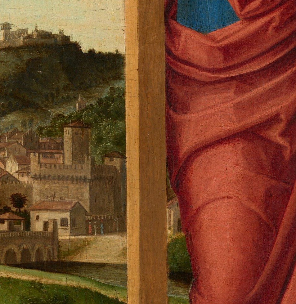 Her right hand holds the cross. Her left hand rests at her side.