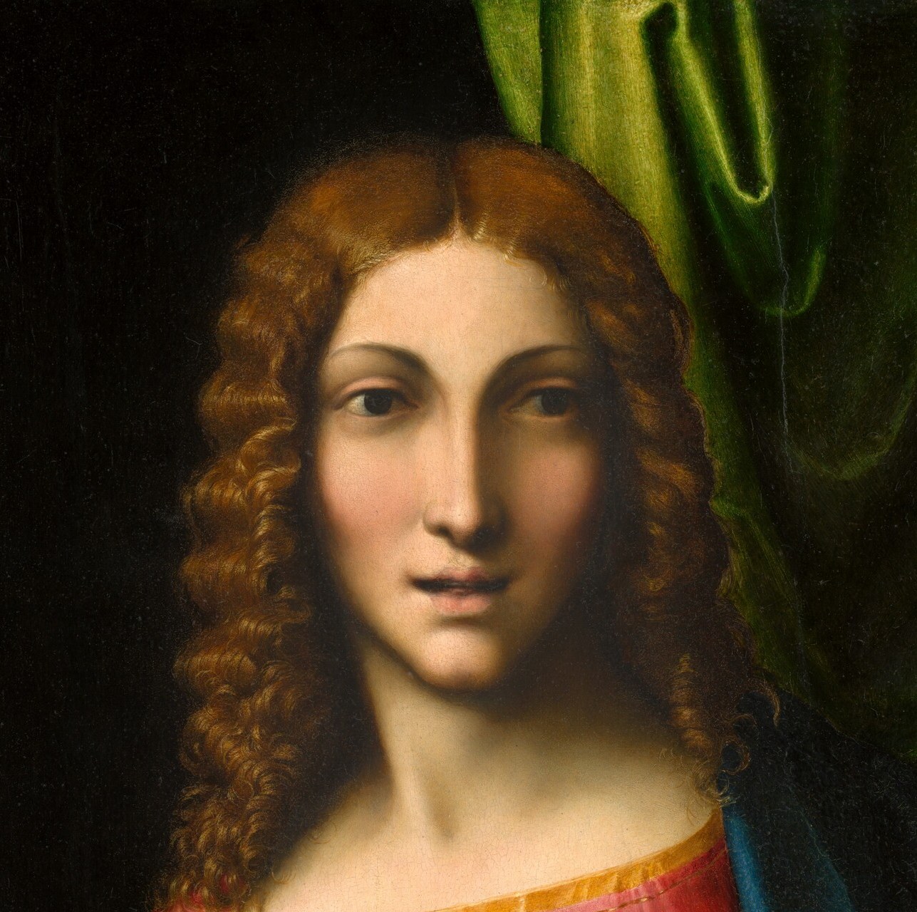 Richly rendered spiraling hair signals youthful divinity; the warm color against dark shadow is among the most sensuous passages in the painting.