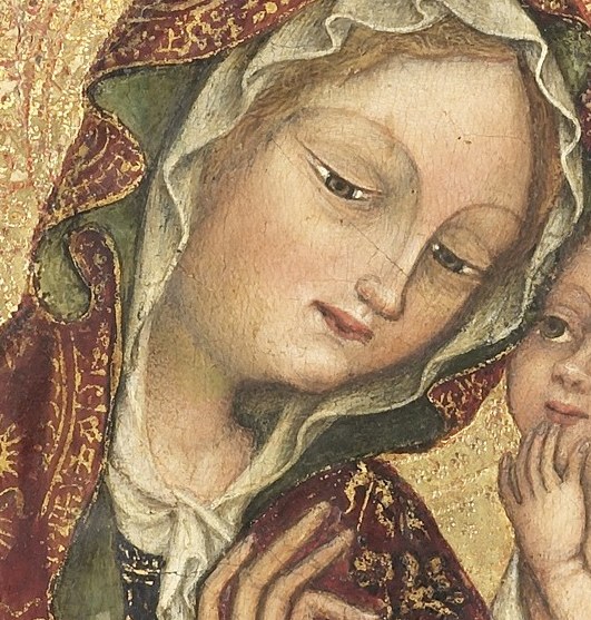 Mary is seated on the ground, a pose called the 'Madonna of Humility'.