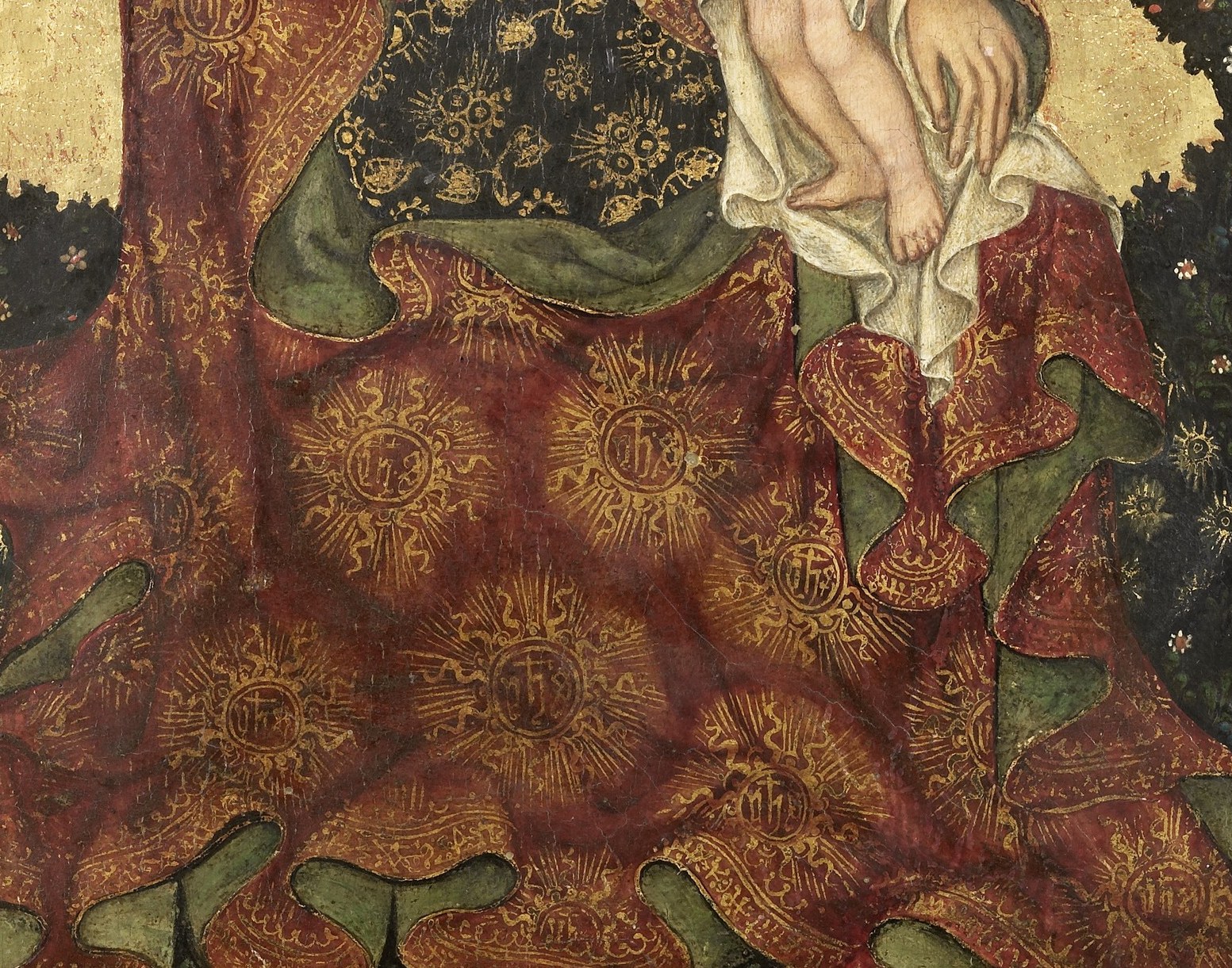 Her robe has a richly patterned gold brocade.