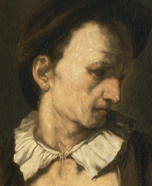 His gaze is inward, his face shadowed by his hat.