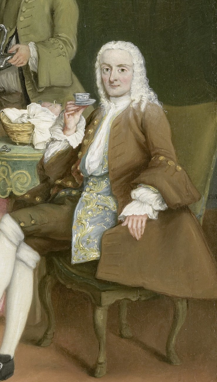 His relaxed posture and engagement with the coffee service suggest a moment of leisure and social interaction.