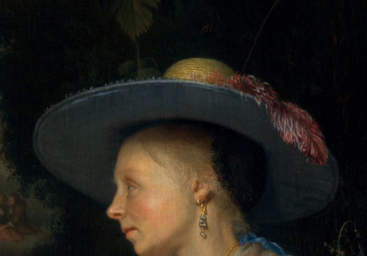 The hat adds a touch of elegance and fashion, framing her face and suggesting a leisurely outdoor setting.