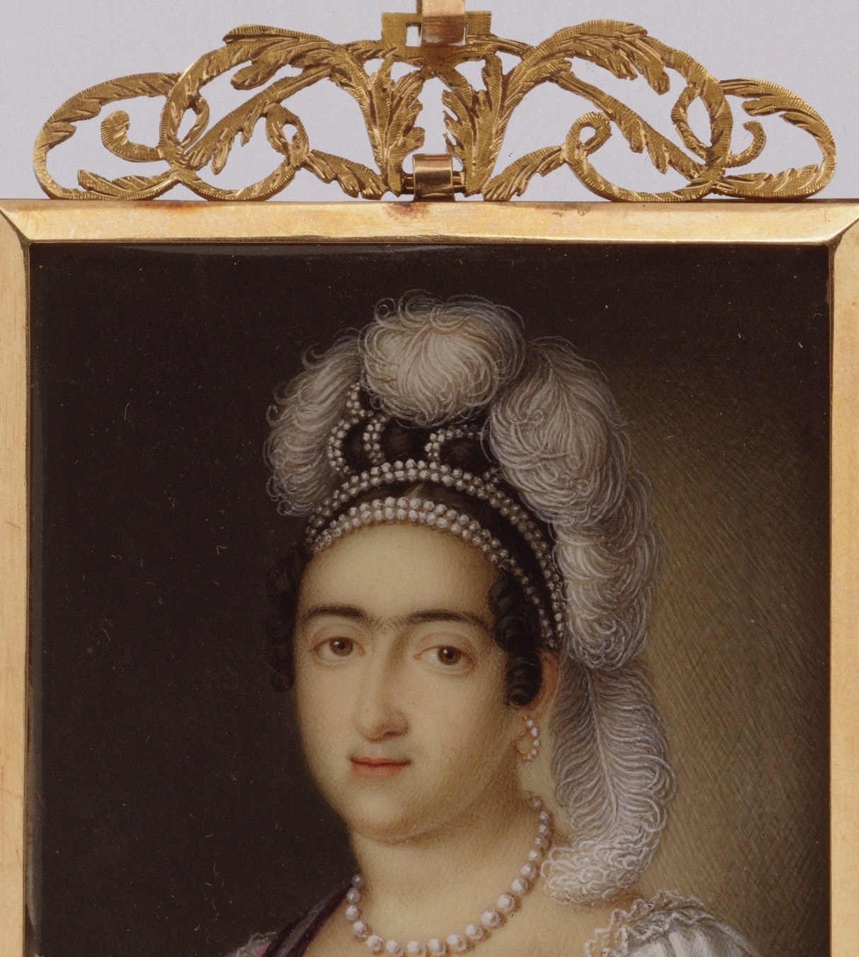 The dark surround concentrates every detail on the sitter and also masks the extreme thinness of the ivory support; the contrast makes her skin appear to emit rather than reflect light.