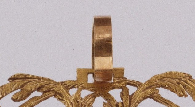 Hidden in plain sight: this loop indicates the miniature was meant to be hung or worn, a use that becomes invisible the moment the object enters a museum vitrine , the entire function of the portrait encoded in one small brass bow.