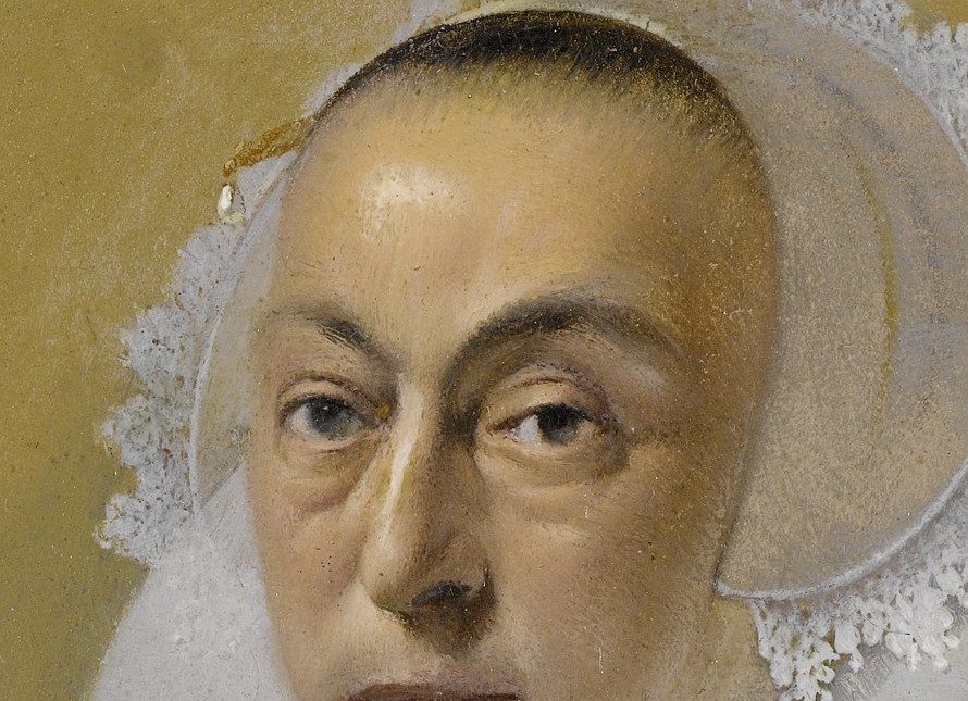 Her delicate cap and starched collar signify status.