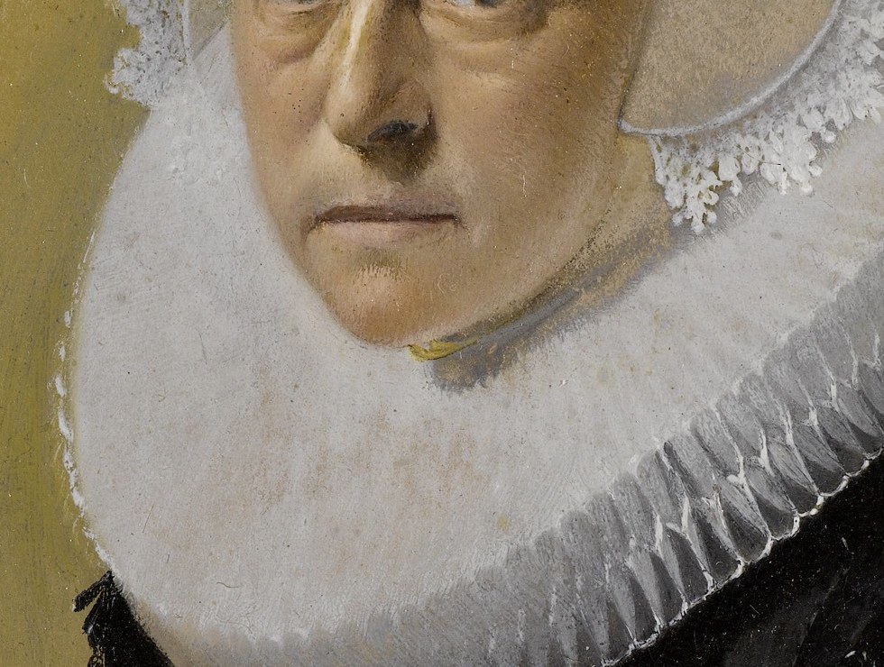 The voluminous, starched collar emphasizes her face and shoulders, a symbol of status and modesty.