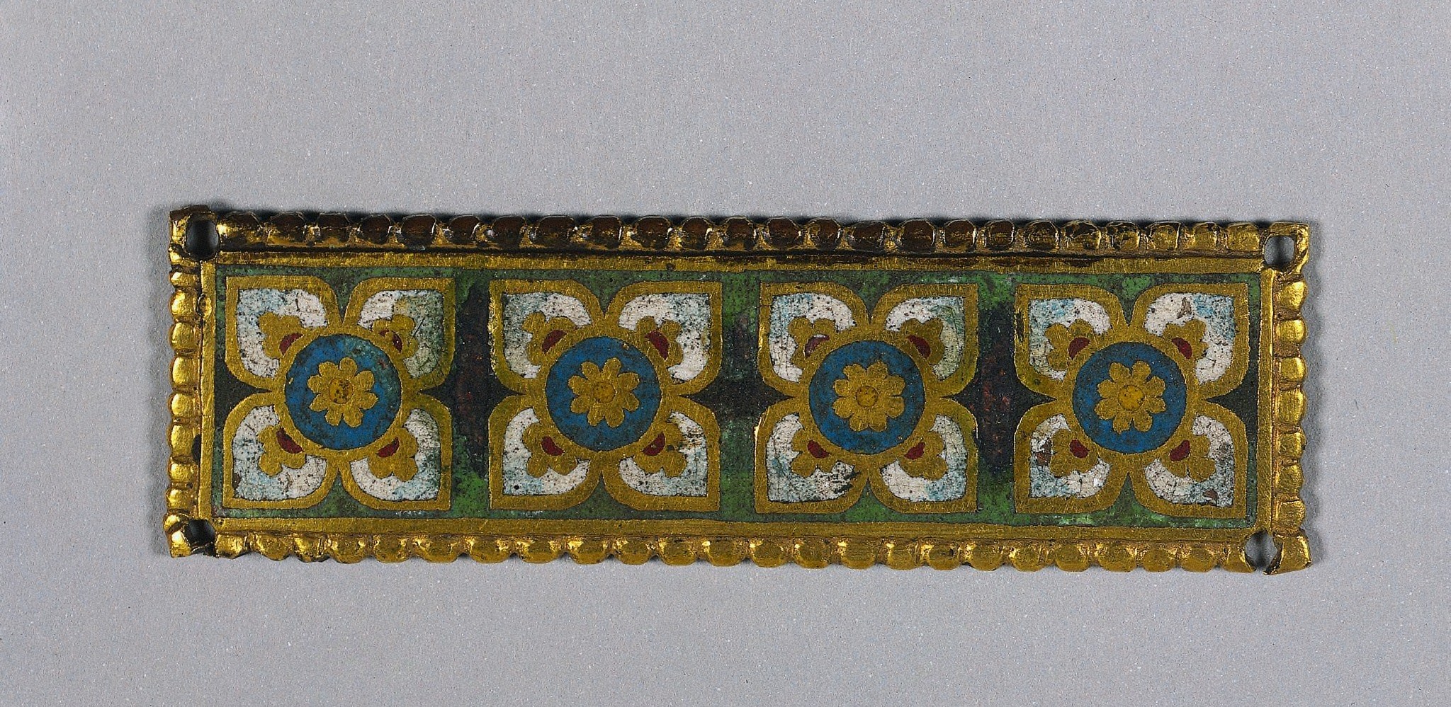 The heavy gold frame immediately signals high-status devotional or ceremonial ware; its proportions and weight define the object's authority before any imagery is read.