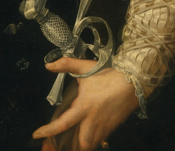 He holds a jeweled dagger, a symbol of power.