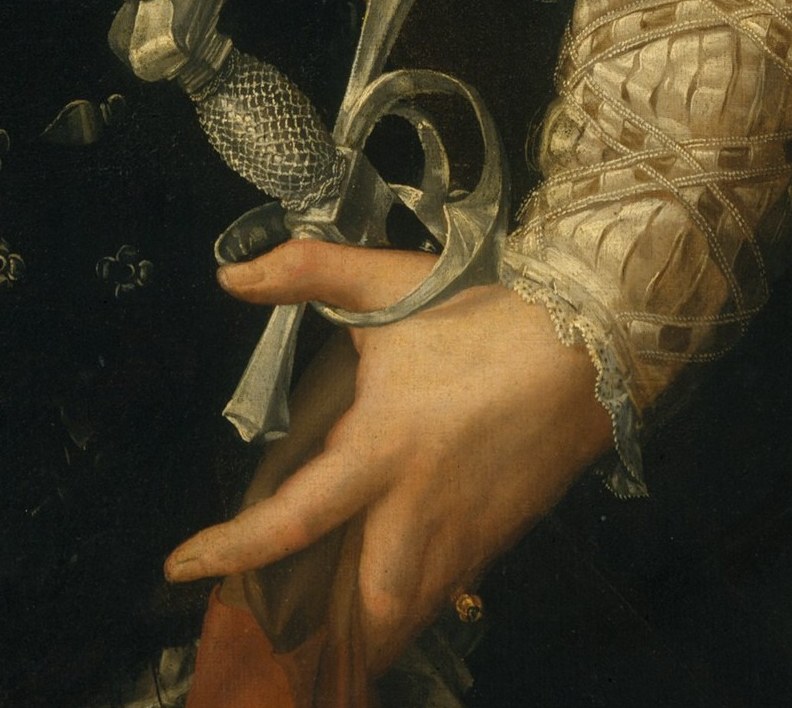 The hand grips a jeweled dagger, a symbol of status, power, and perhaps a hint of danger.