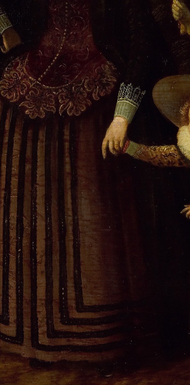 Look closely at the rich fabric of the mother's dress.